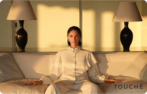 a lady sitting on the sofa with her clothes matching the furniture's upholstery