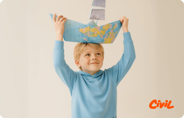 Child holding a paper boat hat